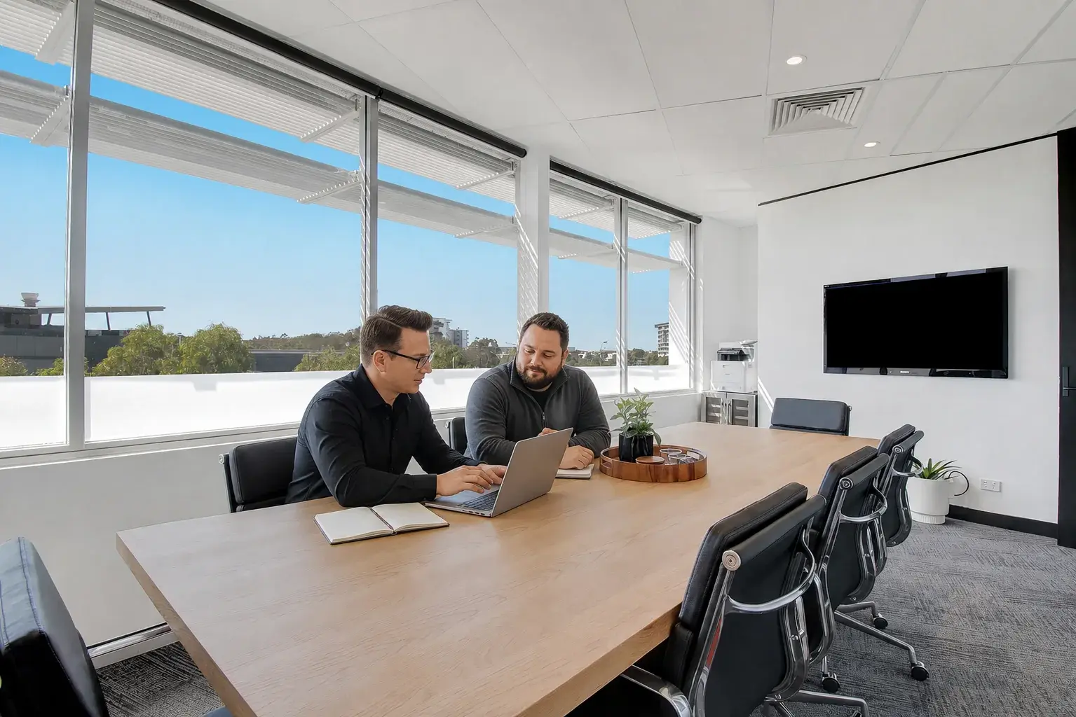 Matt and Ben reviewing campaign plans in a Robina meeting room