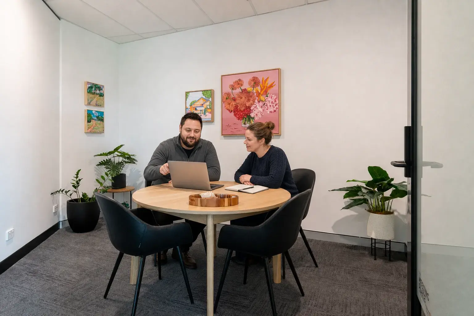 Ben reviewing campaign results with a small-business client in a Robina meeting room