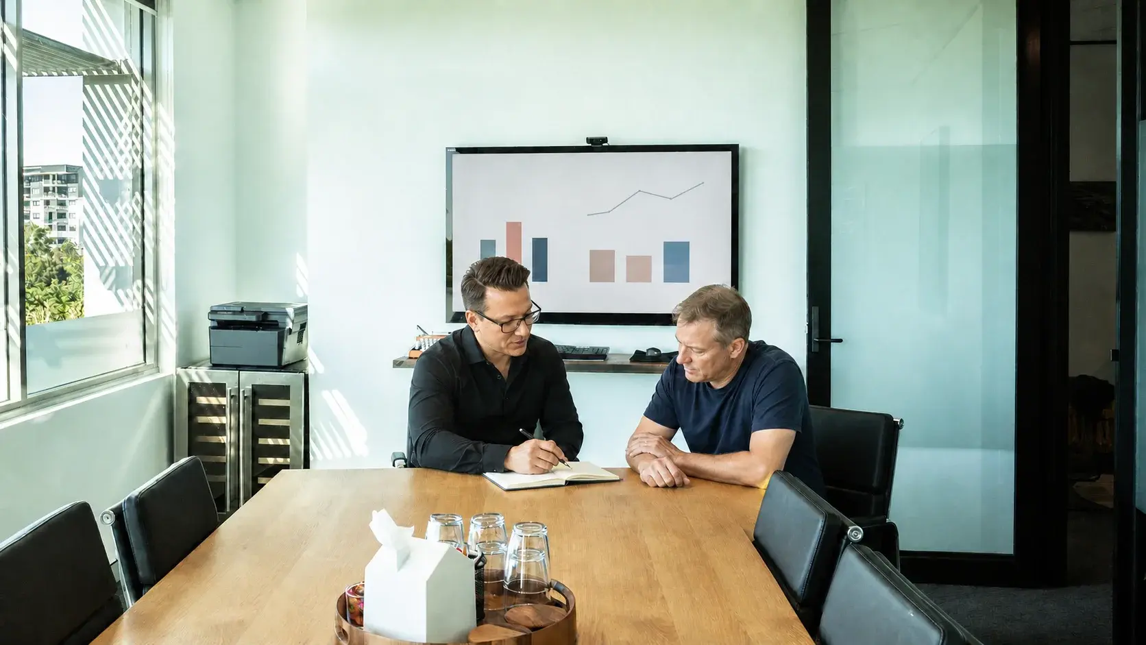Matt explaining a performance report to a small-business client in a Robina meeting room